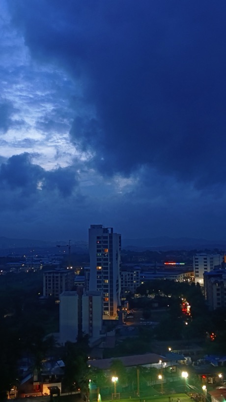 Storm clouds over a city skyline at dusk
